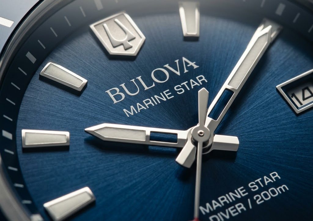 Detalhe do mostrador azul do Bulova Marine Star com &iacute;ndices e ponteiros em close extremo